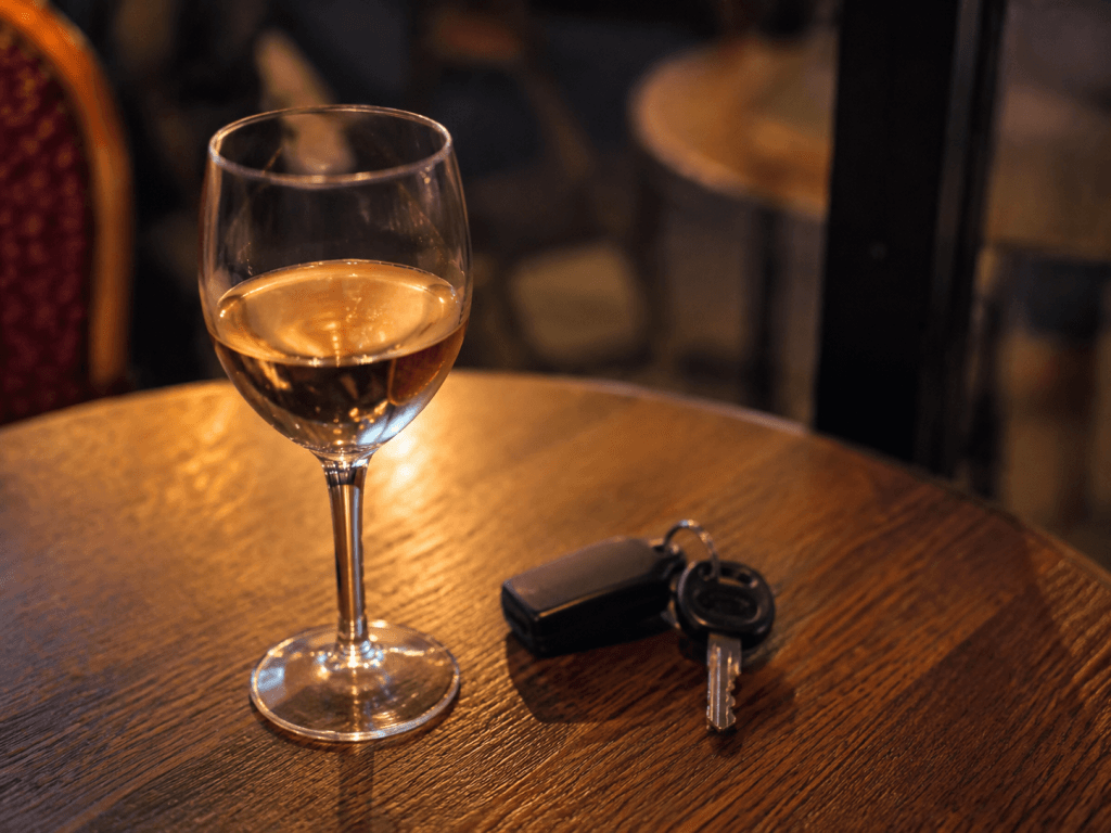 clé de voiture posée à côté d'un verre de rosé